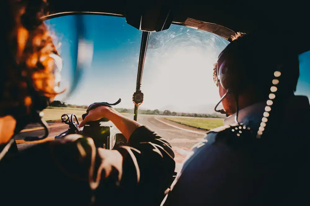 Inside the dark helicopter simulator cockpit facing a mountain landscape